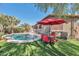 Beautiful backyard with a pool, a red umbrella, artificial turf and a view of the house at 7433 W Darrel Rd, Laveen, AZ 85339