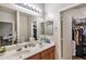 Bright bathroom with a double sink vanity, large mirror, and view into the bedroom and closet at 7433 W Darrel Rd, Laveen, AZ 85339