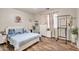 Cozy bedroom with laminate wood flooring, light blue bedding, and ample natural light at 7433 W Darrel Rd, Laveen, AZ 85339