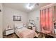 Inviting bedroom featuring a full-size bed with pink floral bedding, a vanity, and a soft chair at 7433 W Darrel Rd, Laveen, AZ 85339