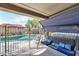 Relaxing covered patio featuring an outdoor swing with pillows and a view of the pool at 7433 W Darrel Rd, Laveen, AZ 85339