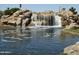 A beautiful rocky waterfall feature creating a serene water landscape at 7433 W Darrel Rd, Laveen, AZ 85339