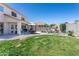 Expansive backyard oasis featuring lush green lawn, a sparkling pool, patio, and mature trees for privacy at 7670 W Sands Dr, Peoria, AZ 85383