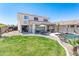 Large backyard featuring a pool, lush lawn, covered patio, and an outdoor dining area; ideal for entertaining at 7670 W Sands Dr, Peoria, AZ 85383