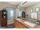 Bathroom with a double sink vanity, granite countertop, and natural lighting at 7670 W Sands Dr, Peoria, AZ 85383