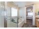 Bathroom featuring a tub, glass shower, and a window to bring in light at 7670 W Sands Dr, Peoria, AZ 85383