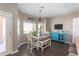 Bright dining area with a farmhouse-style table, bench seating, and a unique turquoise cabinet at 7670 W Sands Dr, Peoria, AZ 85383