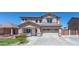 Charming two-story home with attached two car garage, lush landscaping, and a classic desert color palette at 7670 W Sands Dr, Peoria, AZ 85383