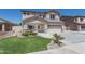 Charming two-story home with lush front yard landscaping and a two car garage featuring a desert color palette at 7670 W Sands Dr, Peoria, AZ 85383