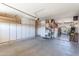 Spacious garage with ample storage cabinets, high ceilings, and access to an outdoor living space at 7670 W Sands Dr, Peoria, AZ 85383