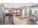 Open floor plan kitchen island with granite countertops, sink, and stainless steel refrigerator at 7670 W Sands Dr, Peoria, AZ 85383