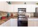 Modern kitchen featuring stainless steel appliances, mosaic tile backsplash, and white cabinetry at 7670 W Sands Dr, Peoria, AZ 85383