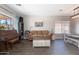 Bright living room area featuring dark floors, neutral color paint, natural lighting, a dining room, and a sofa at 7670 W Sands Dr, Peoria, AZ 85383