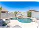 Private backyard oasis with a freeform pool, rock waterfall, and lounge chairs, perfect for summer relaxation at 7670 W Sands Dr, Peoria, AZ 85383