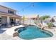 Backyard pool with rock waterfall feature, surrounding patio, and lush landscaping; a private oasis at 7670 W Sands Dr, Peoria, AZ 85383