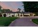 Beautiful single-story home with lush landscaping and illuminated walkway at dusk at 8031 N 12Th Ave, Phoenix, AZ 85021