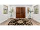 Elegant foyer with wooden double doors, round rug, hardwood floors and natural light at 8031 N 12Th Ave, Phoenix, AZ 85021