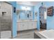 Bright bathroom featuring double sinks, white cabinetry, walk-in shower, and a separate soaking tub at 8429 S 229Th Ln, Buckeye, AZ 85326