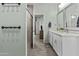 Bathroom featuring double sinks and a walk-in shower, with light-green walls and a light-colored tiled floor at 8429 S 229Th Ln, Buckeye, AZ 85326