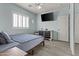 Bedroom featuring light blue walls, wood-look tile flooring, plantation shutters, and modern decor at 8429 S 229Th Ln, Buckeye, AZ 85326