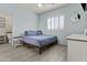 Bedroom with light blue walls, wood-look tile flooring, plantation shutters, and casual decor at 8429 S 229Th Ln, Buckeye, AZ 85326