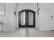 Elegant entryway with an ornate iron door, light blue walls, and stylish flooring at 8429 S 229Th Ln, Buckeye, AZ 85326