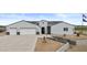 Attractive ranch home boasts a three-car garage, manicured lawn, and contemporary design with solar panels at 8429 S 229Th Ln, Buckeye, AZ 85326