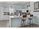 Bright kitchen with white cabinetry, a stainless-steel fridge, and a breakfast bar with seating at 8429 S 229Th Ln, Buckeye, AZ 85326