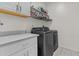 Modern laundry room featuring sleek gray washer and dryer with white cabinets and countertops at 8429 S 229Th Ln, Buckeye, AZ 85326