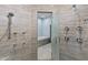 Oversized shower showcasing extensive tile work, multiple shower heads, and a glass door to the Primary bath at 8429 S 229Th Ln, Buckeye, AZ 85326