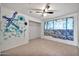 Bright bedroom featuring a ceiling fan and natural light from the window at 9102 N 56Th Ln, Glendale, AZ 85302