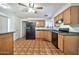 The kitchen is equipped with wood cabinets and black appliances, highlighted by a ceiling fan at 9102 N 56Th Ln, Glendale, AZ 85302