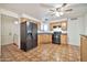 Well-lit kitchen featuring a black refrigerator, wood cabinetry, and a ceiling fan for added comfort at 9102 N 56Th Ln, Glendale, AZ 85302