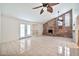 Open living space with tile flooring, brick fireplace, and access to the outdoor space at 9102 N 56Th Ln, Glendale, AZ 85302