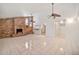 Open living space with a brick fireplace, white tile flooring, and two ceiling fans for optimal comfort at 9102 N 56Th Ln, Glendale, AZ 85302