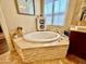 Elegant bathtub with travertine surround, perfect for relaxation, in a well-appointed bathroom at 9249 E Desert Arroyos St, Scottsdale, AZ 85255