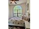 Cozy bedroom with a large window, comfortable bed with floral bedding, and a side table with lamp at 9249 E Desert Arroyos St, Scottsdale, AZ 85255