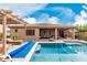 Backyard pool oasis with a covered patio, lounge chairs, lush landscaping and a sparkling pool, perfect for entertaining at 9390 W Louise Dr, Peoria, AZ 85383