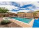 Inviting backyard pool features a pergola-covered seating area, lush landscaping, and a calming water feature at 9390 W Louise Dr, Peoria, AZ 85383