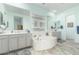 Bright bathroom highlighting a corner soaking tub with tiled flooring and double sink vanities at 9390 W Louise Dr, Peoria, AZ 85383