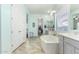 Bright bathroom with large soaking tub and tiled flooring, offering a spa-like experience at 9390 W Louise Dr, Peoria, AZ 85383