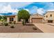 Well-kept single-level home boasting a two-car garage, desert landscaping, and mature trees at 9390 W Louise Dr, Peoria, AZ 85383