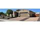 Charming single-Gathering home featuring a two-car garage, neutral stucco exterior, and brick-paved driveway at 9390 W Louise Dr, Peoria, AZ 85383