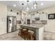 Modern kitchen features stainless steel appliances, white cabinets, and a functional island with seating at 9390 W Louise Dr, Peoria, AZ 85383