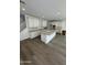 Open kitchen showcasing white cabinets, an island, and wood-style floors at 2467 W Rowel Rd, Phoenix, AZ 85085