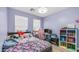 This bedroom is decorated with purple walls, colorful décor, plush pillows, and a desk for gaming at 6092 S Bridal Vail Dr, Gilbert, AZ 85298
