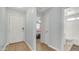 Hallway view of entry door, bathroom, and bedroom with light blue walls and wood flooring at 6092 S Bridal Vail Dr, Gilbert, AZ 85298