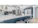Well-lit kitchen featuring an island with bar seating, stainless steel appliances, and pantry door at 6092 S Bridal Vail Dr, Gilbert, AZ 85298
