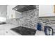 Modern kitchen featuring white cabinets, gray backsplash, and stainless steel range hood at 6092 S Bridal Vail Dr, Gilbert, AZ 85298