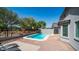 This backyard pool has bright blue water, brick accents, a patio area, backyard trees and lounge chairs at 6092 S Bridal Vail Dr, Gilbert, AZ 85298